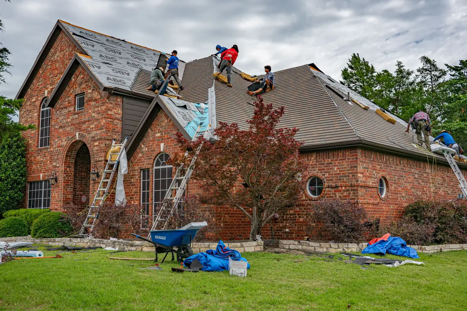 A roofing crew working on a brick home